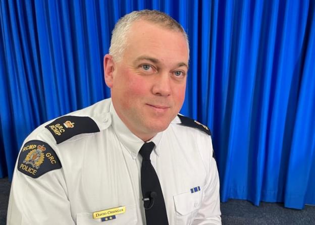 a portrait style photo of RCMP officer David Ossinger, seated at a table.