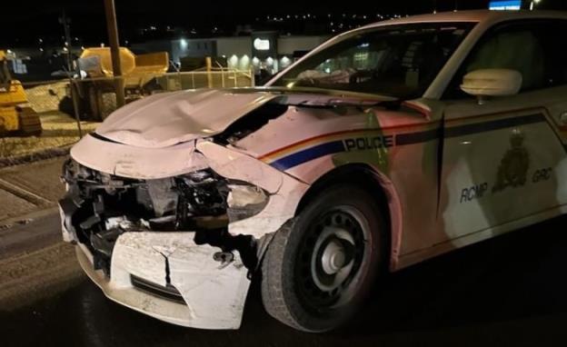 a photo of a crumpled RCMP vehicle. Photo is taken in darkness.