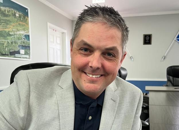 a portrait style photo of Ryan Snow, sitting in the council chamber in the Town of South River.