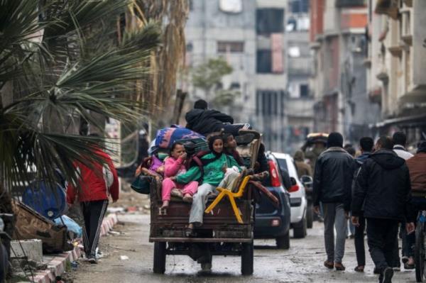 a family on the back of a small vehicle carrying belongings