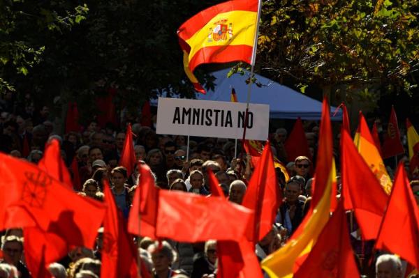 Demo<em></em>nstrators hold up a banner reading: 