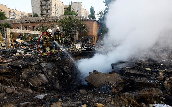 Firefighters work at a site in a residential area, damaged during a Russian missile strike on Kyiv