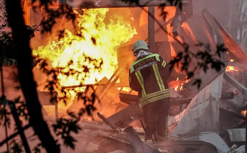 Ukrainian rescuers work at the site of a missile strike on a residential area in Kyiv