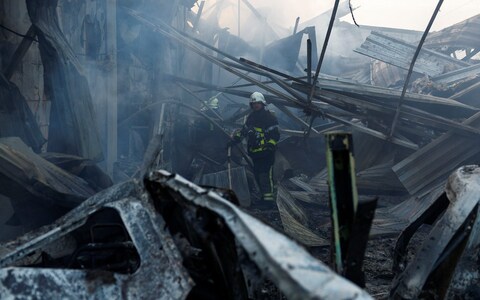 Ukrainian rescuers work at the site of a missile strike on a residential area in Kyiv