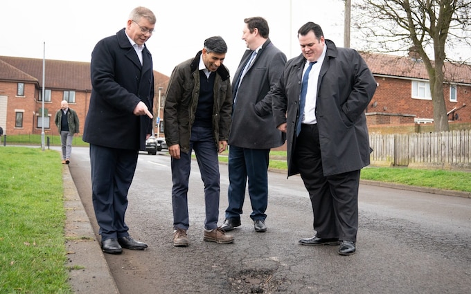 Rishi Sunak looks at pothole