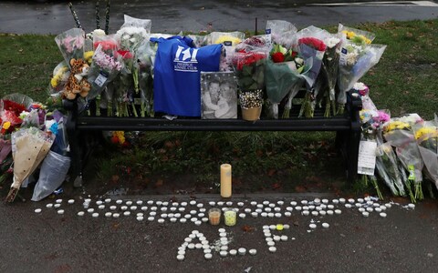 Flowers are laid on a bench at the scene