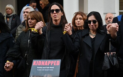 People wearing yellow ribbons hold hands as they gather outside the Qatari Embassy in Lo<em></em>ndon on October 29, 2023, to demand the release of the estimated 230 hostages held in Gaza by Hamas after the attacks inside Israel on October 7. 