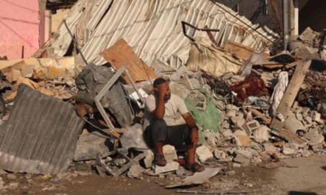 A Palestinian man sits on the debris of buildings destroyed in the Israeli bombardment of Rafah in the southern Gaza Strip on Friday.