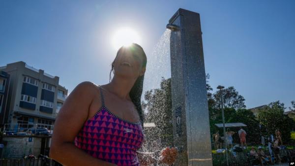 FILE - A woman showers at Sydney's Bo<em></em>ndi beach as temperatures in excess of 40 degrees Celsius (104 Fahrenheit) hit parts of eastern Australia on Dec. 9, 2023.