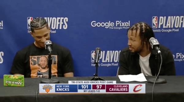 Josh Hart (l.) dons a shirt with Jalen Brunson's face on it while sitting next to him following the Knicks' Game 1 win over the Cavaliers on April 15, 2023.