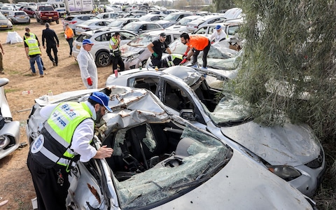 Volunteers from the Zaka emergency respo<em></em>nse team inspect vehicles destroyed in the Oct 7 attack 