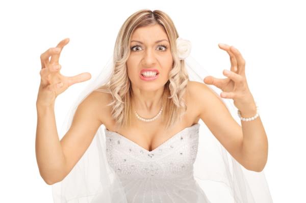 Angry bride threatening to strangle someone and looking at the camera isolated on white background.