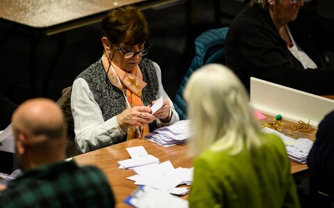 Count staff look on as a box of ballot papers is emptied at the Wellingborough by-election count centre