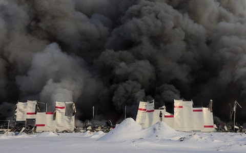 Smoke from the fire rises above the burning warehouse