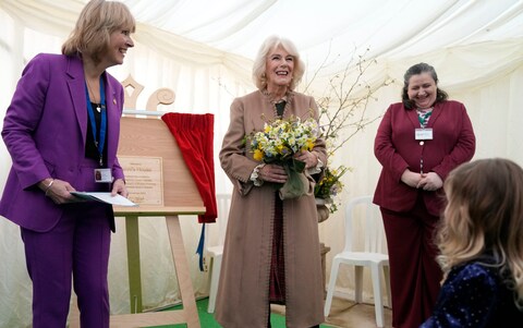 Queen Camilla smiles after unveiling a plaque during a visit to the Swindon Domestic Abuse Support Service