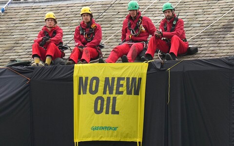 Greenpeace activists on the roof of Prime Minister Rishi Sunak's house in Richmond, North Yorkshire after covering it in black fabric in protest at his backing for expansion of North Sea oil and gas drilling.