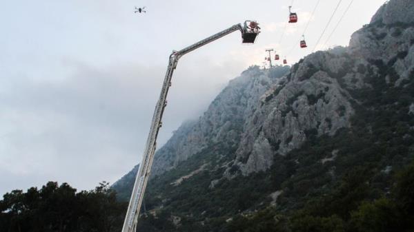 A rescue team work with passengers of a cable car transportation systems outside Antalya, southern Turkey, April, Friday 12, 2024. A cable car disaster in southern Turkey left one person dead and seven injured over the busy Eid al-Fitr public holiday on Friday, local media reported. (IHA via AP)