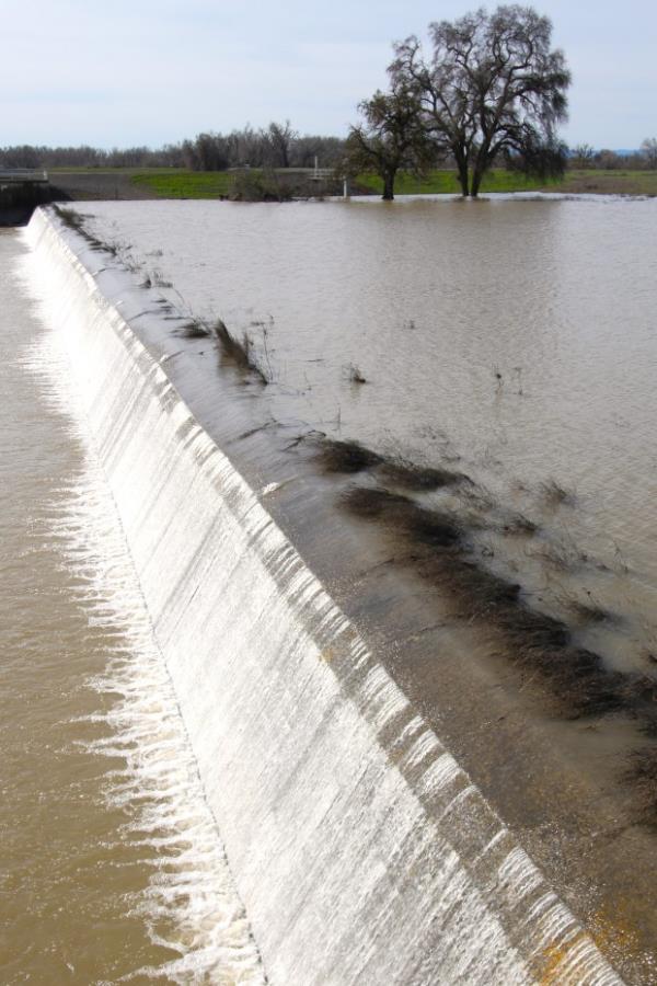 Floodwater flows over Moulton Weir just past the lower edge...