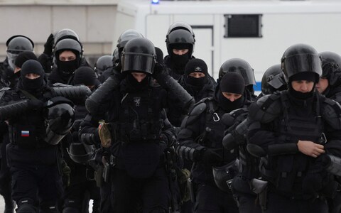 Law enforcement officers stand guard near the Solovetsky Stone mo<em></em>nument to the victims of political repressions