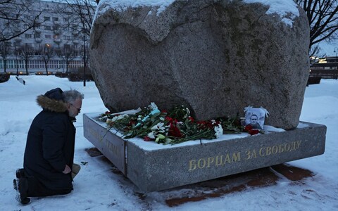 A man kneels at the mo<em></em>nument to the victims of political repressions, wher<em></em>e people lay flowers following the death of Russian opposition leader Alexei Navalny, in Saint Petersburg, Russia February 16, 2024.