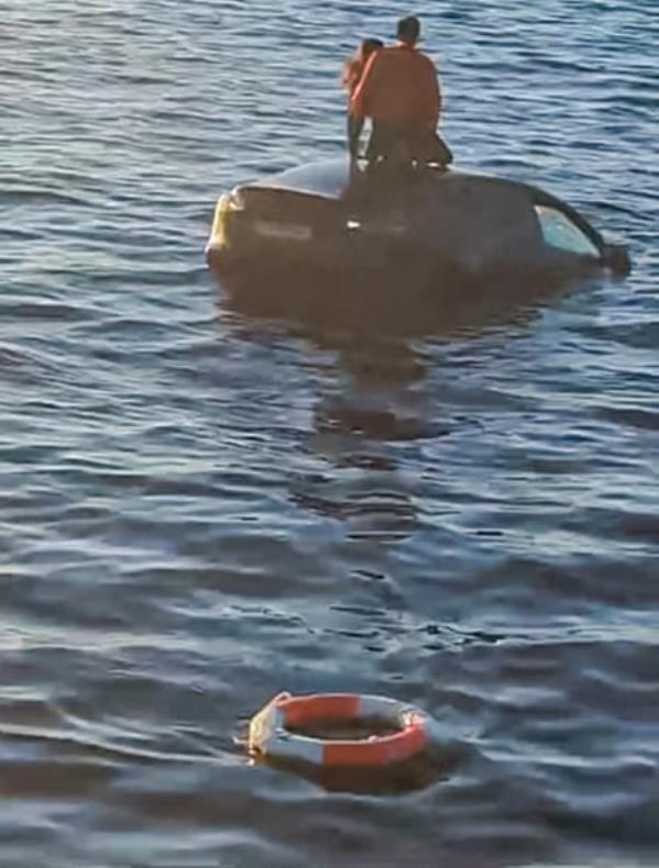 Two people await rescue atop their Tesla in Oslo fjord.