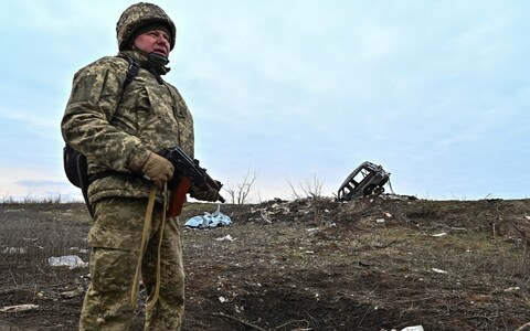 A Ukrainian serviceman of the 65th Mechanised Brigade near a damaged car at the fro<em></em>ntline village of Robotyne, in Zaporizhzhia region, on Wednesday