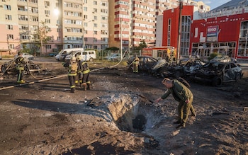 People look on crater after Russian air strike on residential neighbourhood in Sumy, Ukraine