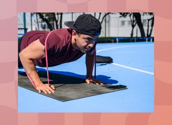 fit, focused man doing banded pushups on mat