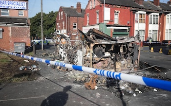 Police tape cordons off the remains of the burnt out bus