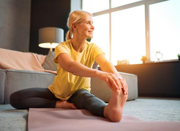 woman stretching indoors, co<em></em>ncept of weight loss habits