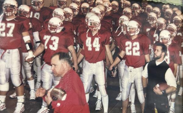 Defensive coordinator Tim Walz, center, and head coach Rick Sutton, right, with the Mankato West football team before winning the state champio<em></em>nship game in 1999.