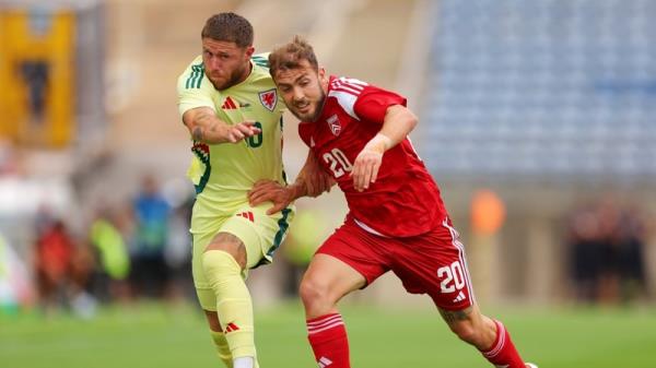 Wes Burns of Wales (ll) battles with Ethan Britto in Faro