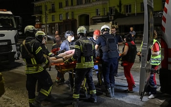 Rescuers and medical workers treat a wounded local resident at a site of a Russian missile strike, amid Russia's attack on Ukraine, in Kryvyi Rih,