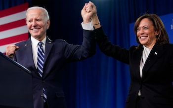 President Joe Biden, left, and Vice President Kamala Harris stand on stage at the Democratic Natio<em></em>nal Committee winter meeting