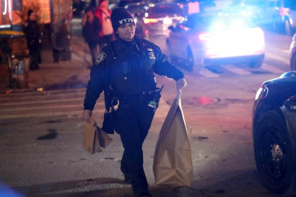 An officer carries evidence at the crime scene. 