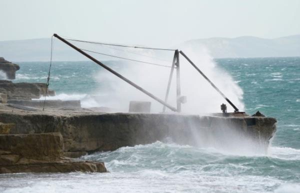 Waves crash against the shoreline at Portland Bill in Dorset