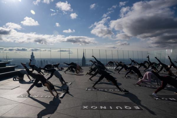 People participating in 'Sky High' yoga class on 100th story observation deck at The Edge, Hudson Yards, New York City