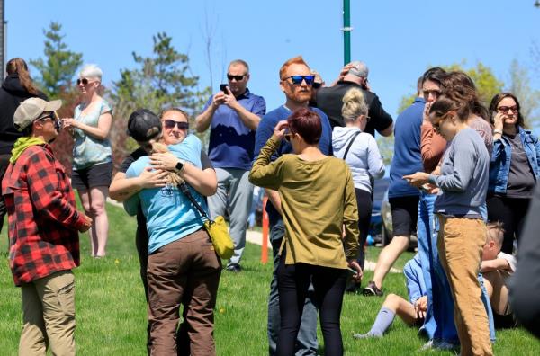 People gather at a site designated for parent and student reunifications outside Mount Horeb Middle School on Wednesday.