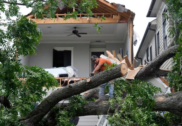 Crews work to clean up debris after a wall came down in the aftermath of a severe storm on Friday, May 17, 2024 in Houston. 