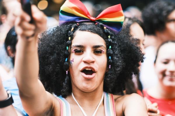 A reveler waves a rainbow flag.