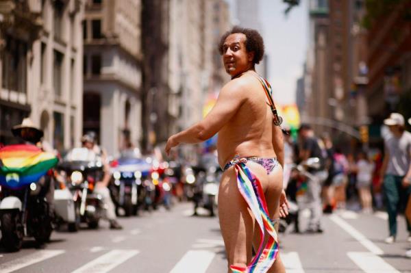 A nearly-naked man walks down the parade rout,