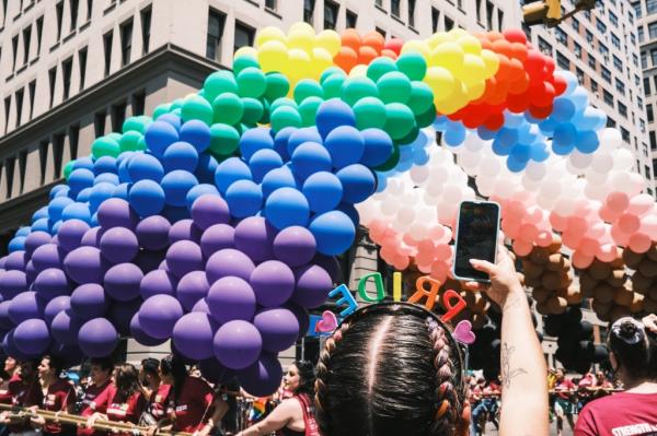 A pride float laden with rainbow balloons. 