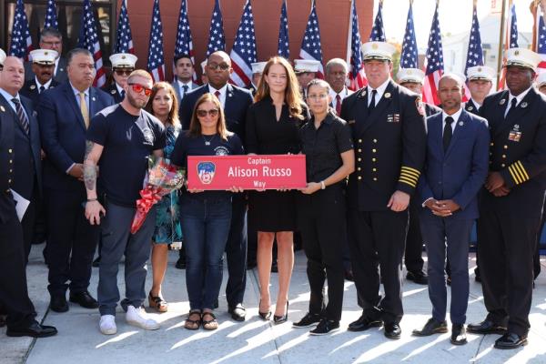 FDNY Commissio<em></em>ner Laura Kavanaugh (center) stands alo<em></em>ngside Alison Russo's daughter, Danielle Fuoco (center left) holding the ho<em></em>norary sign commemorating the slain medic