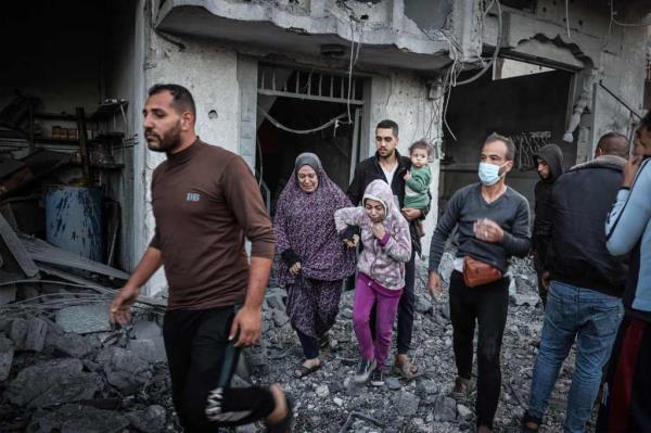 Residents flea through the rubble of Rafah on Thursday, after Israeli artillery fell on the city in the southern Gaza Strip