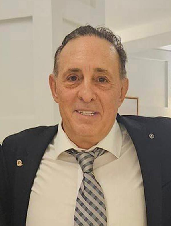 Sam Esposito, president of the Ozone Park Block Association, posing in a suit and tie