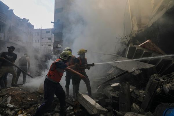 Palestinian civil defence perso<em></em>nnel work at the site of an Israeli rocket attack in Al-Shati refugee camp in the west of Gaza City.