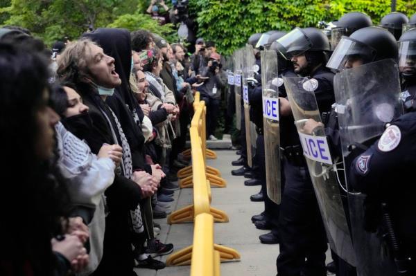 Pro-Palestinian protesters chant at University of Chicago police while being kept from the university's quad as the student encampment is dismantled Tuesday, May 7, 2024, in Chicago. 