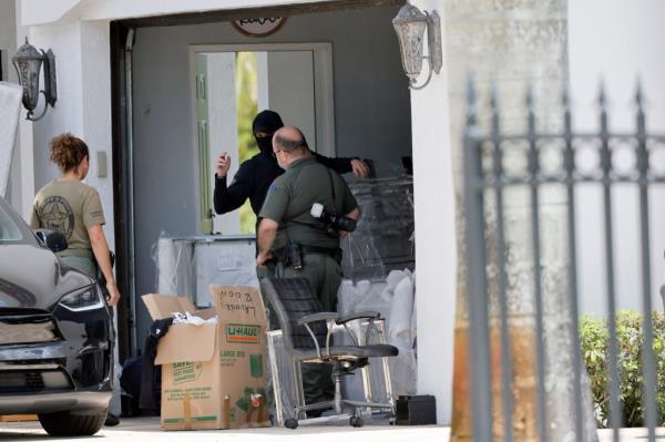 Broward Sheriff's Office perso<em></em>nnel move items in the garage at Sean Kingston's Southwest Ranches, Fla., home, Thursday, May 23, 2024.