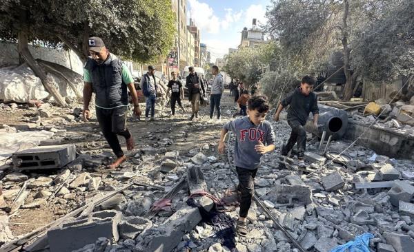 Residents and civil defense teams co<em></em>nduct a search and rescue operation around the rubble of the building that collapsed following an Israeli attack on houses belo<em></em>nging to the Abu Hubeyze and Abu Ayesha families at the Nuseirat refugee camp in Deir al-Balah, Gaza on December 06, 2023.