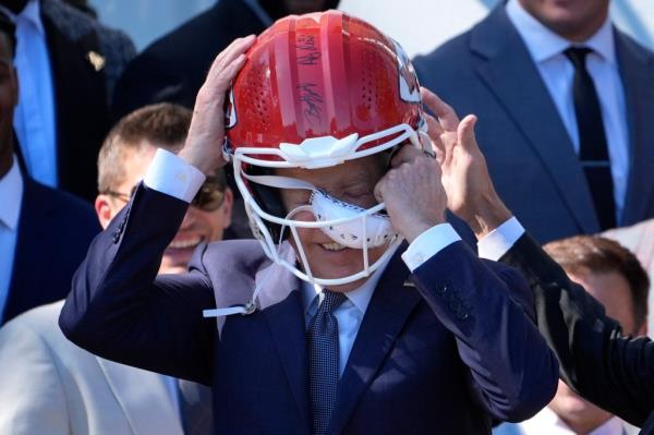 Biden was goaded into wearing the helmet by Chiefs tight end Travis Kelce, who urged him to 